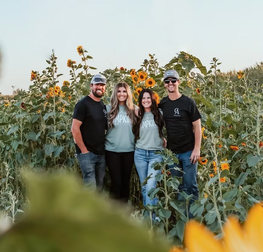 The family who runs Cherry Acres, standing together in the farm’s sunflower field